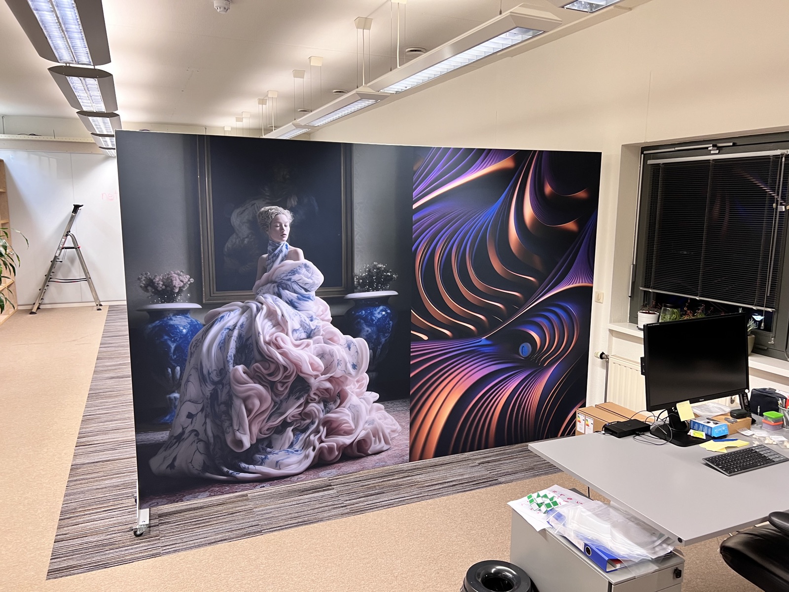 Akoestische room divider op locatie: textielportret in blauw naast koperkleurige abstractie bij werkplekken